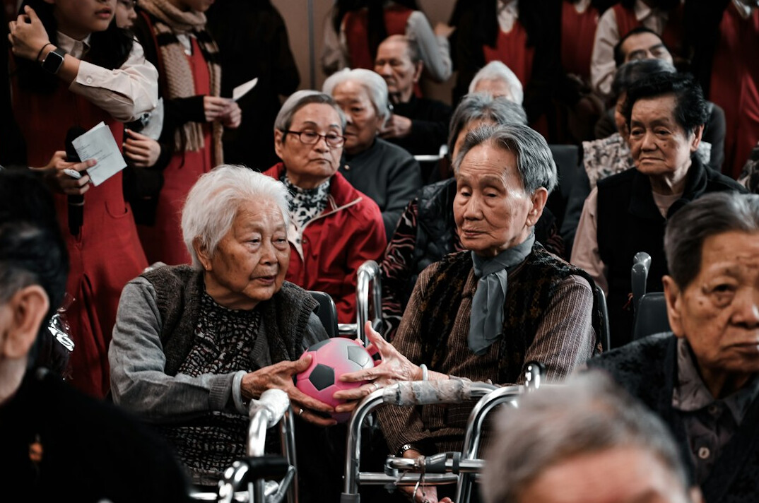 group of elderly women knitting