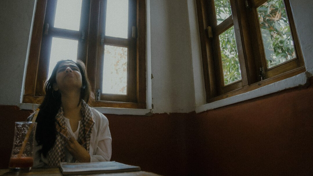 woman drinking tea by window